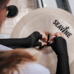 black seavine fingerless cymbal gloves with a model holding a cymbal