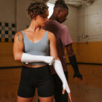 white seavine fingerless cymbal gloves with two models in a gym
