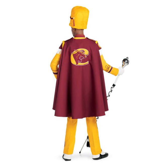 Custom yellow with brick trim marching band uniform. Back view with white gloves and yellow busby hat and pants and brick cape with yellow logo holding amazing mace