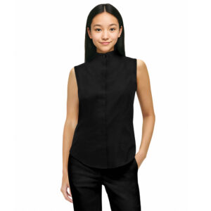 smiling model wearing a black band-collar sleeveless shirt and black pants with one hand in her pocket, front view