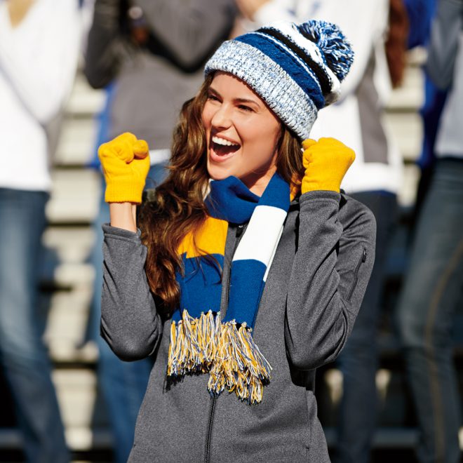 royal/yello/white sport tek spectator scarf around neck with blue and white hat, yellow gloves, and grey jacket front view of model in stands