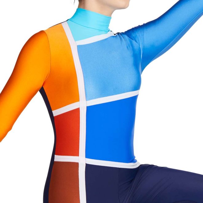 Close up of custom navy, orange, brown and blue long sleeve color guard tunic with left blue sleeve and right orange sleeve. Shades of blue and orange sections separated by white stripes with navy pants with brown stripe front view on model
