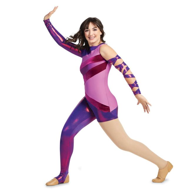 Custom color guard unitard. Right arm sleeveless, left arm long sleeve metallic purple. Body has pieces of shades of purple. Right leg long legging left leg boy short both are metallic purple. Front view on model with metallic purple fabric wrapped around left arm