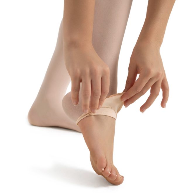 Model wearing a tan capezio body tight, transition foot demonstration