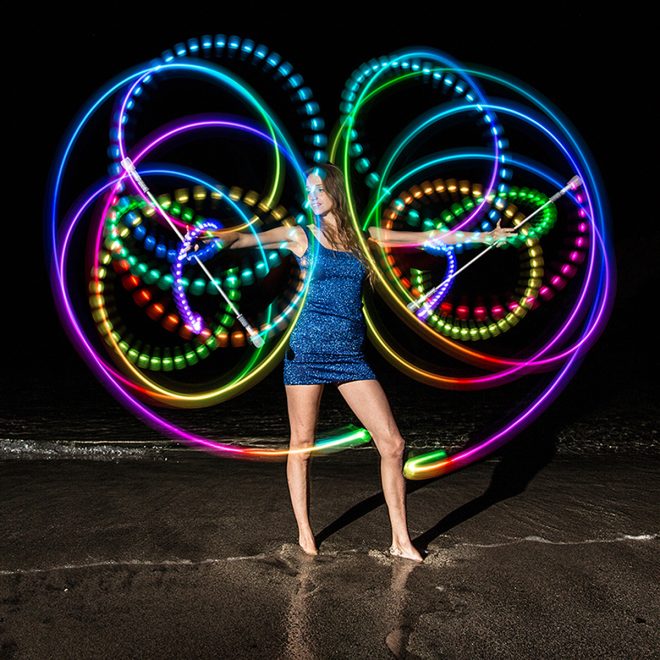 lumina v2 light up twirling baton twirled by performer in dark showing path of colors