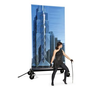 band shoppe prop cart holding scene of tall buildings with performer in front wearing black uniform holding sabre