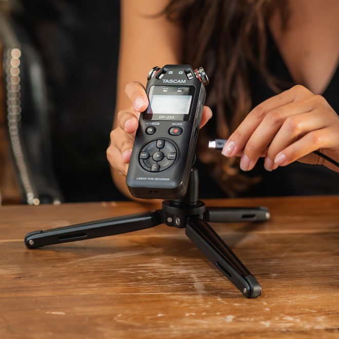 tacsam handheld audio recorder dr05x on stand in front of person