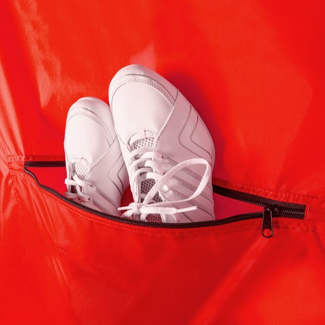 red deluxe garment bag with white shoes in zipper pocket