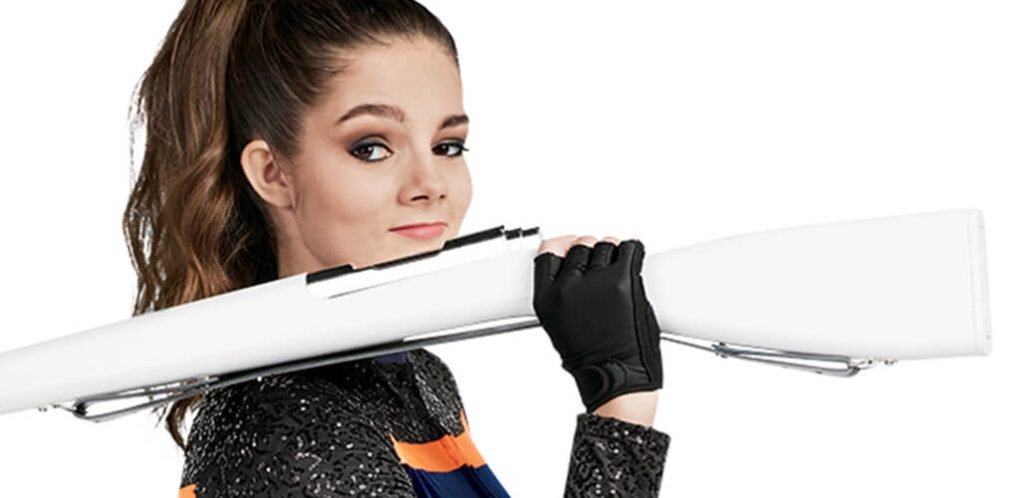 Color guard member wearing fingerless gloves holding a white ultra spin color guard spinning rifle prop.