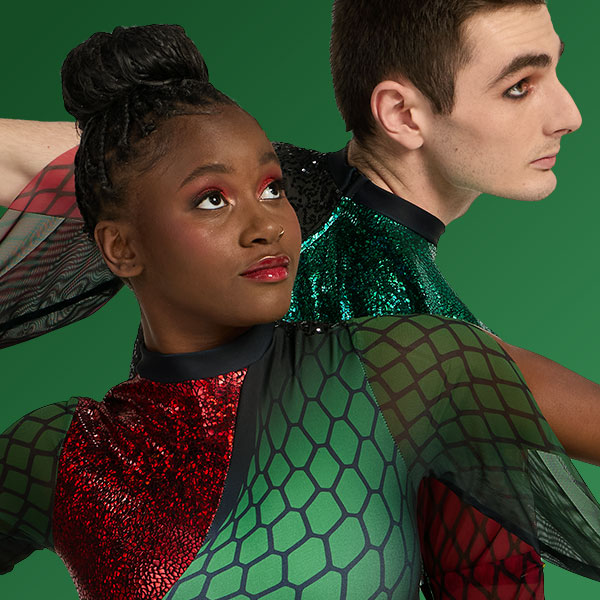 Two color guard performers in red and green performance uniforms posing back-to-back.